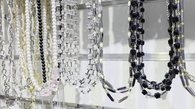 Assortment of elegant fashion necklaces with various beads and chains, showcasing diverse styles and colors on display in a jewelry store, ready for purchase.