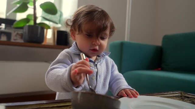 Toddler investigating kitchen utensils during play, building curiosity, fine motor skills and early cognitive development