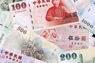 Fototapeta premium Taiwanese dollar money bills pile on table. Taiwan banknotes of TWD currency close up.