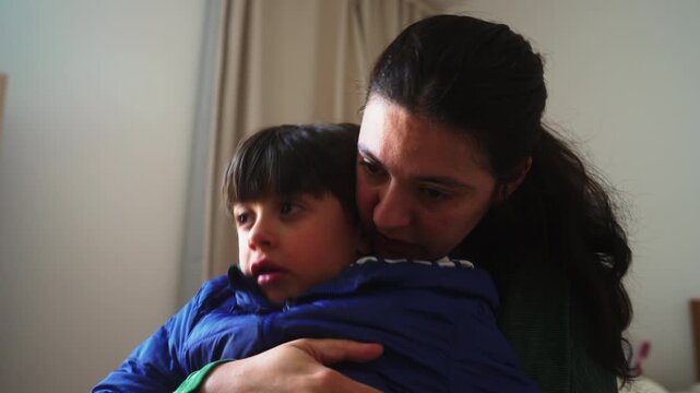 Mother comforts sad school age son with gentle embrace at home, providing emotional reassurance, secure attachment, unconditional love and compassionate family support