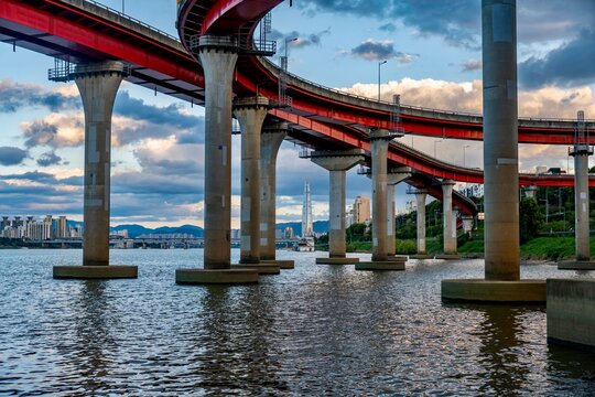 Red bridge structure over Han River with Seoul skyline and Lotte World Tower in background, South Korea