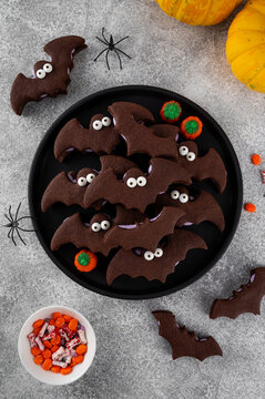 Halloween cookies. Chocolate sandwich cookies in the shape of a bat with eyes and butter cream. Funny food idea. Top view.