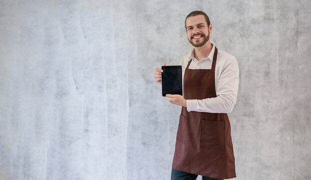 Startup successful small business owner caucasian man wear apron digital tablet sme, men in coffee shop restaurant. Portrait of barista cafe local owner hold gadget. SME sell online delivery
