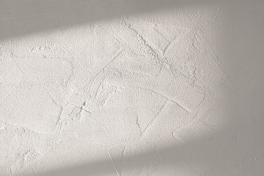 Warm White Plaster Wall Texture with Sunlight Shadow Overlay Background