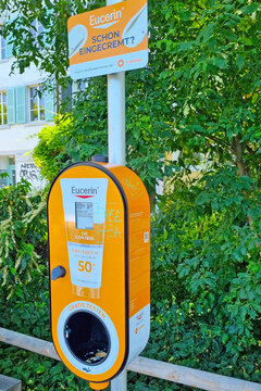 Basel, Switzerland, May 24, 2026: Eucerin Sunscreen Dispenser in Urban Park Setting for Summer Outdoor Skincare