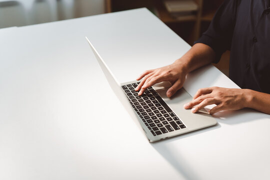 Hands typing on a laptop keyboard and using the touchpad, representing focused remote work, data entry, coding, and modern productivity in home or office settings