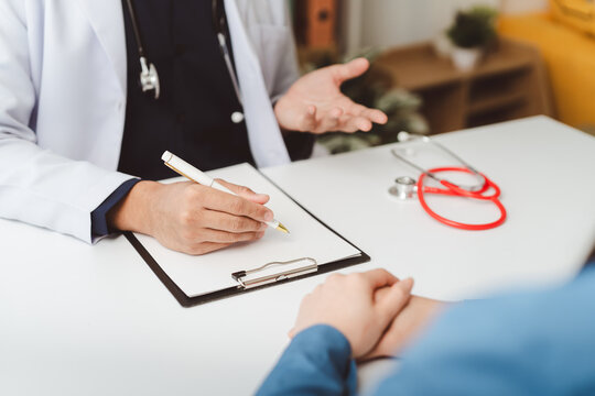 Doctor discussing medical information with patient, explaining diagnosis, treatment, and filling out patient history, ensuring comprehensive health care and support