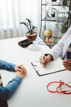 Doctor discussing patient history and health examination, medical professional recording data during consultation, providing care and treatment plan