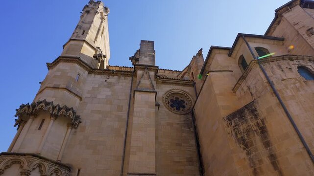 Low angle view of the side tower and stone walls of Cuenca Cathedral in Spain