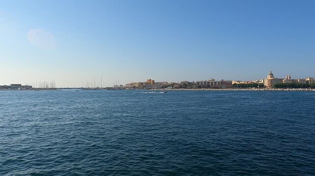 Trapani. Approaching the harbor by boat, with Mediterranean waters and waterfront buildings. Sicily, Italy
