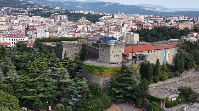 Flight over San Giusto Castle hill landmark in Trieste city, Italy