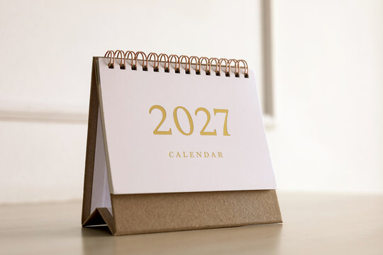 2027 desk calendar with gold numbers on craft paper base. Concept of new year resolution, annual planning, and time management.