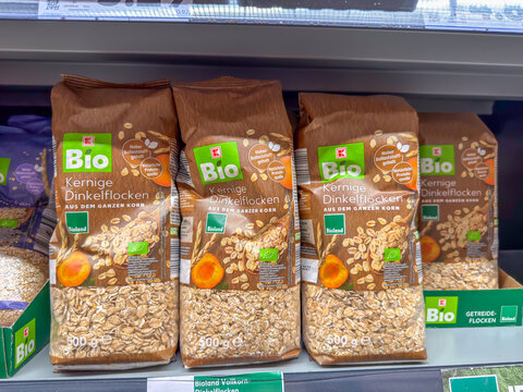 Berlin, Germany July 29, 2026. Brown paper packages of organic spelt flakes line a grocery store shelf. Labels highlight the whole grain content and high fiber value of this certified cereal.