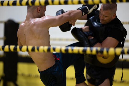 Kickboxing Sparring Session in Ring With Coach Holding Pads During Intense Training Workout