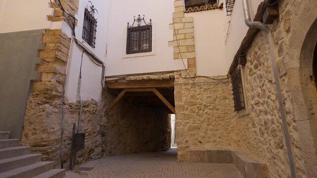 Small historic square with covered passage and stone buildings in the old quarter of Cuenca Spain