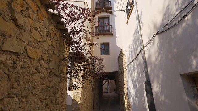 Narrow medieval alley with stone walls and an overhanging house in the old town of Cuenca Spain
