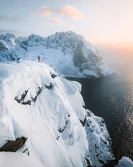 Hiker on Ryten mountain cliff edge at sunset, Lofoten Islands, Norway © JFL Photography