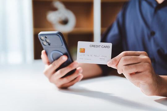 Person holding a credit card and mobile phone, illustrating secure online shopping, convenient digital payments, and e-commerce transactions for modern banking