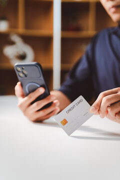 Person is using a credit card for online shopping, making a secure mobile payment and banking transaction through a smartphone, representing modern digital finance