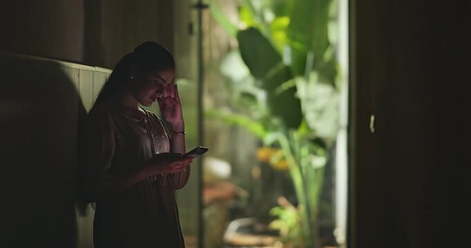 Indian young adult gen z stress sad woman use mobile look screen read bad news indoor dark home. Upset tense girl hold phone check mail lost job result fail feel hurt living room place