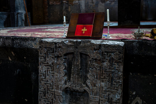 Carved Stone Khachkar in Ancient Church Altar with Holy Book and Candles