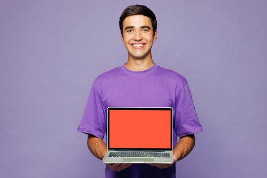 Young IT man wear violet t-shirt casual clothes hold use work on laptop pc computer with blank screen workspace area isolated on plain pastel light purple background studio portrait Lifestyle concept