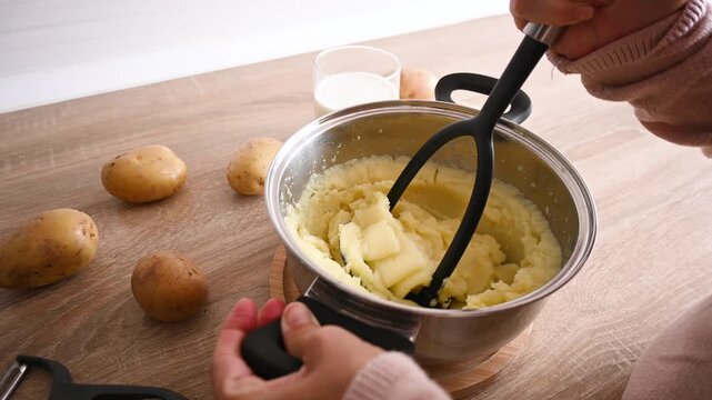 Preparing mashed potatoes by mashing boiled potatoes