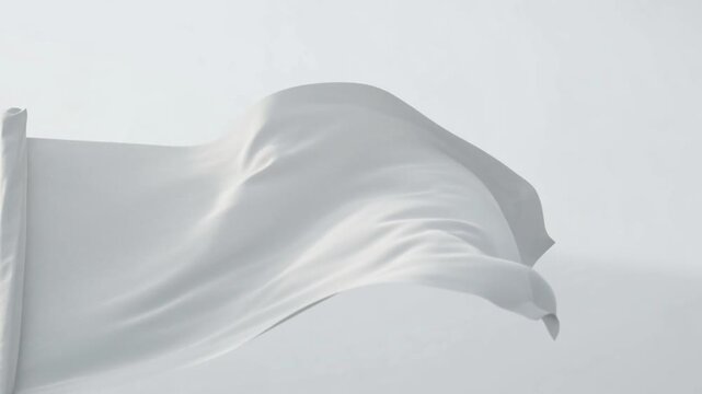 White flag waving in the wind against a clear light sky symbolizing surrender, peace, truce, or a clean minimalist canvas