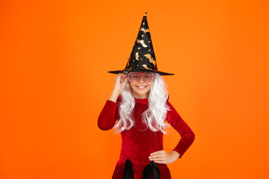 All Hallows. October 31. Teen girl in witch costume. Happy Halloween. Girl witch in Halloween costume isolated on orange. Trick or treat. Celebrate All Hallows party holiday