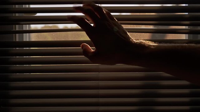Person Peeking Through Partially Open Window Blinds to Secretly Observe the Outside View, Close Up, Curiosity, Surveillance