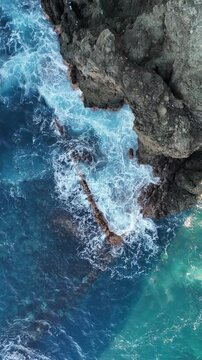 Ocean waves crash against the rocks.