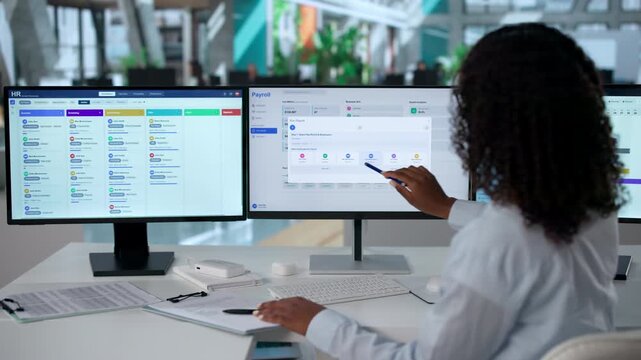 HR Manager Carefully Reviews Employee Payroll On Computer Screen