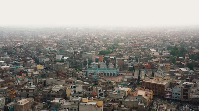 Aerial Drone Zoom Out of Jamia Masjid Surrounded by Dense Urban Cityscape in Pakistan