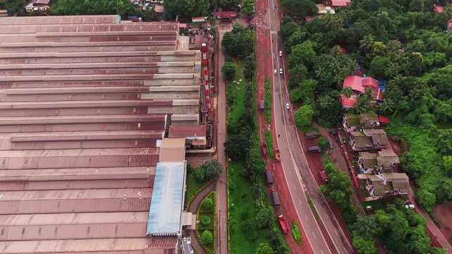 Tyre manufacturing factory beside a highway cutting through dense forest terrain