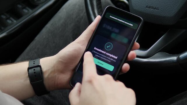 Person tracks portfolio growth on a smartphone and completes a new investment, highlighting mobile wealth management, market participation and digital financial planning.
