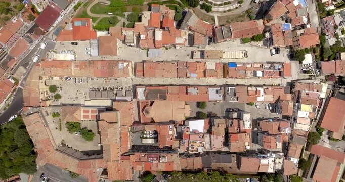 Aerial view of San Felice Circeo, a historic Italian village, showing its traditional layout with red-tiled roofs, stone buildings, and narrow streets. The dense urban fabric is encircled by walls.