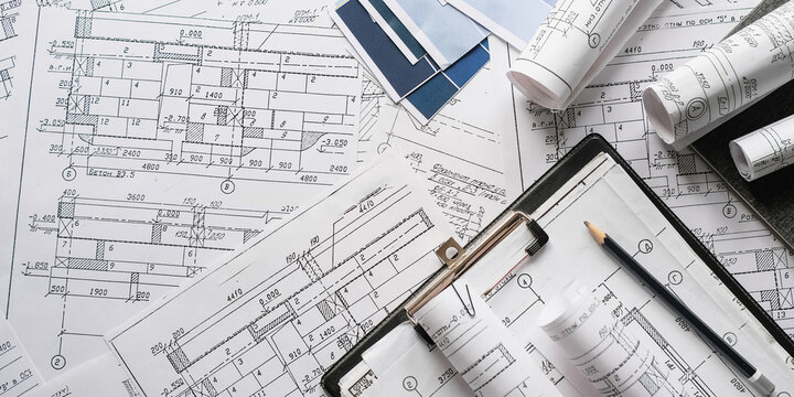 Blueprints, rolled plans and drafting tools on desk, architectural engineering workflow concept for construction planning, technical documentation, project management and building design.