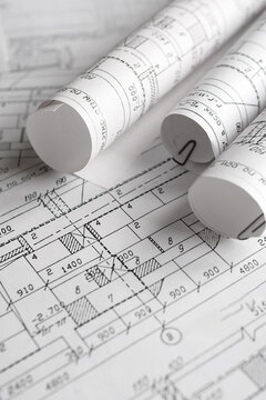 Blueprints, rolled plans and drafting tools on desk, architectural engineering workflow concept for construction planning, technical documentation, project management and building design.
