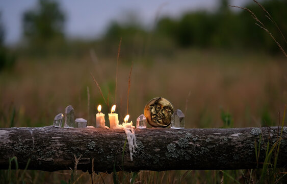 quartz crystals, moon amulet and burning candles outdoor, abstract dark natural background. Witchcraft, Esoteric spiritual ritual, practical magic for life balance, soul calming. soft focus