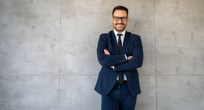 Portrait of a successful handsome business man standing in a modern corporate office