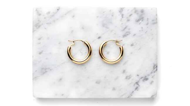 Elegant Gold Hoop Earrings on Marble Surface.