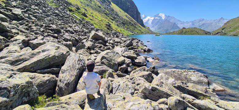 Landscape view of a boy looking at the mountains, shot near Verbier, Valais, Switzerland