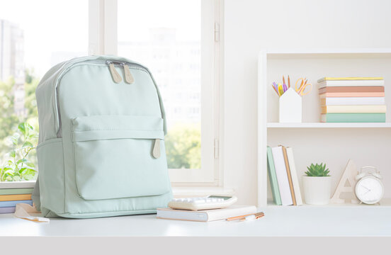 Study desk with notebooks and backpack on home window view background