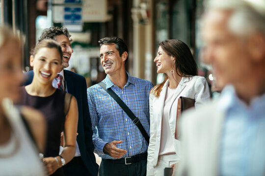 Business colleagues walking and laughing on city street