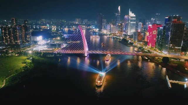 Aerial View of Dinner Cruise Boat Navigating Saigon River at Night in Ho Chi Minh City
bright boat searchlights, colorful reflections across the water, the lit-up cable-stayed bridge, glowing downtown
