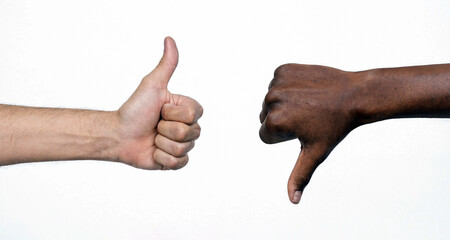 Hands with thumb up and thumb down isolated on white background. Two hands showing thumbs up and thumbs down on white background symbolizing approval and disapproval. © Luis