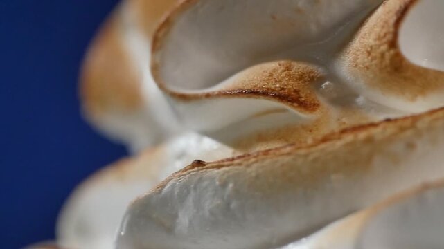 Close up of torched meringue. Overhead view of lemon meringue tart. toasted meringue. Delicious mint-flavored cupcake with golden toasted meringue topping, set against a blurred pastel background