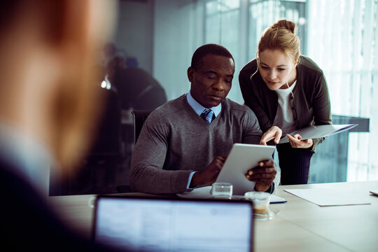 Colleagues reviewing data on tablet in modern office