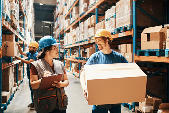 Warehouse workers discussing inventory in distribution aisle