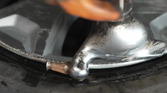 A tire changing machine mounting a tire onto an alloy rim.